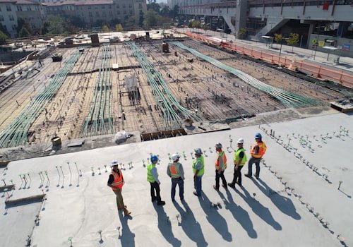 A construction crew in hi-vis and hard hats on a large job site